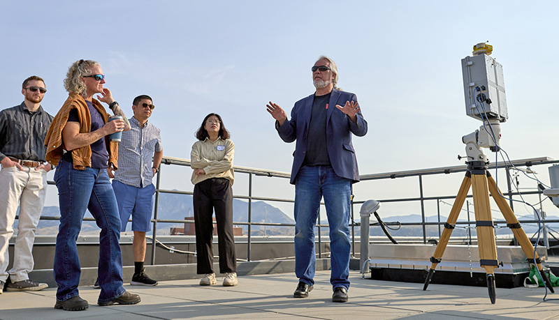 people standing on a rooftop listening to a presenter
