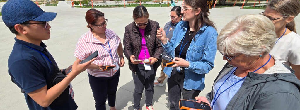 people outdoors using handheld devices to measure air quality