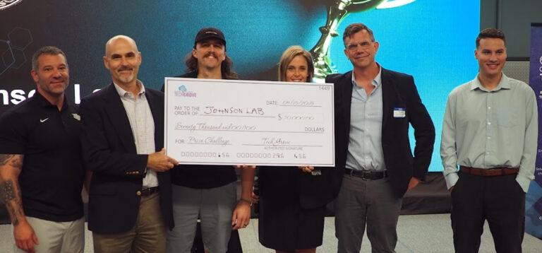 a group of people holding up a large check for $70,000