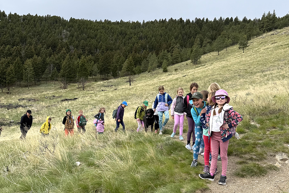 kids hiking on a trail in a prairie