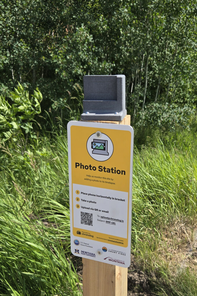 a metal sign on a post says, "PhotoStation" and has instructions for how to take and send a photo from this spot